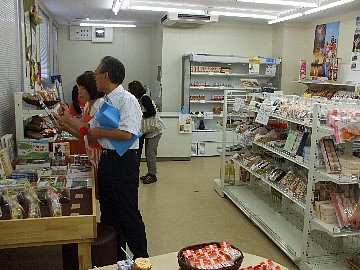 売店の中で様々な商品を手に取り眺めるお客さんたちの写真